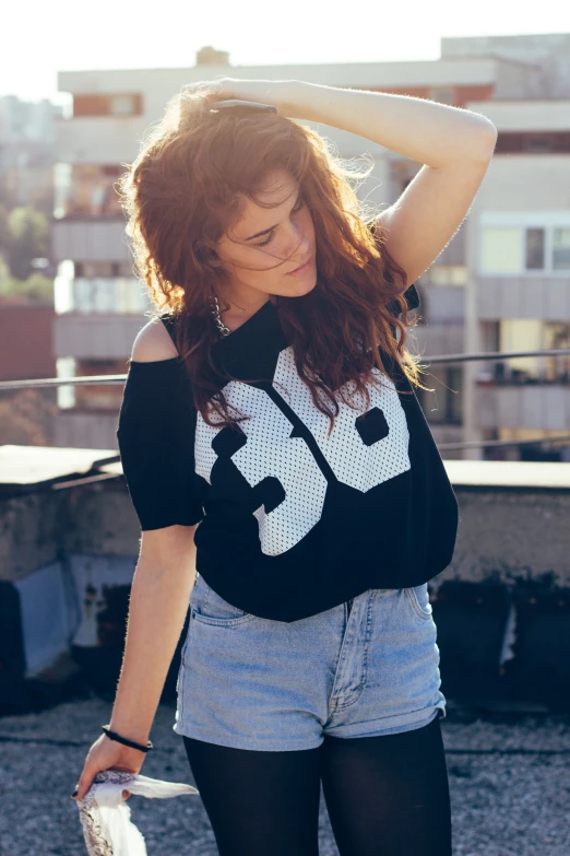 a woman in black shirt and blue shorts with her hair in the air