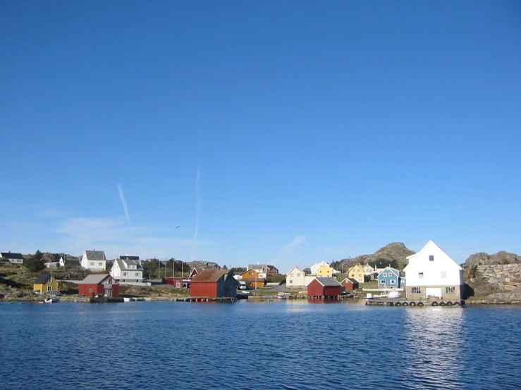 the water is quiet and blue in the middle of a small town