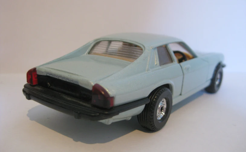 a small model of a vintage, pale green sports car