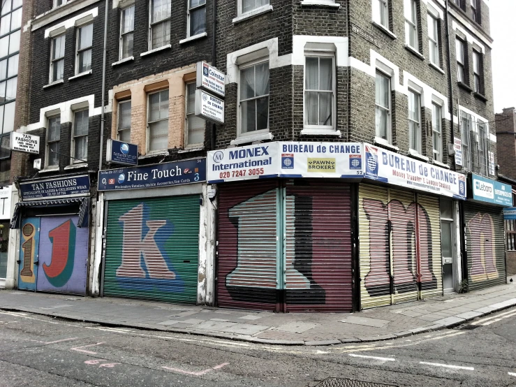 a large building with a few multi - colored shuttered shops