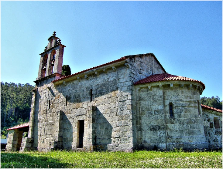 a stone church sits in front of a hill