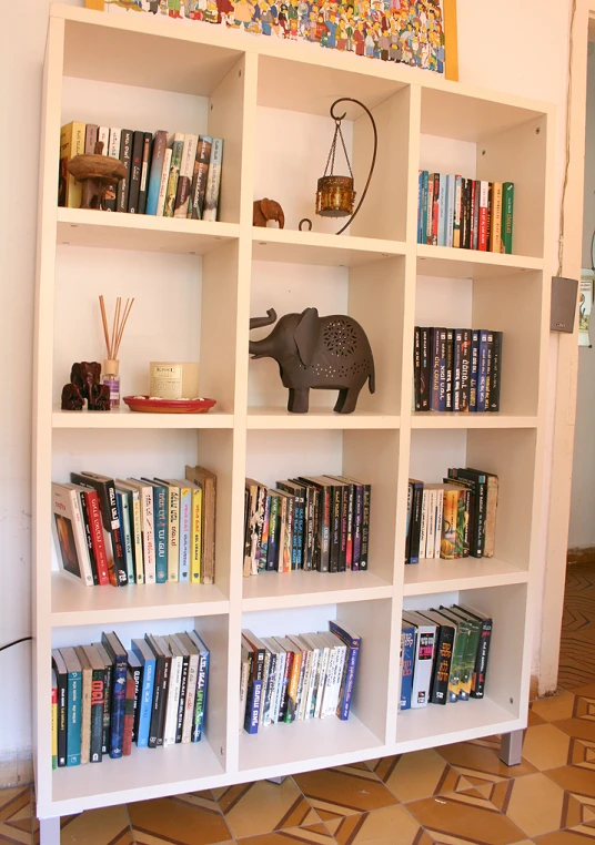 white bookcase full of colorful books and toys