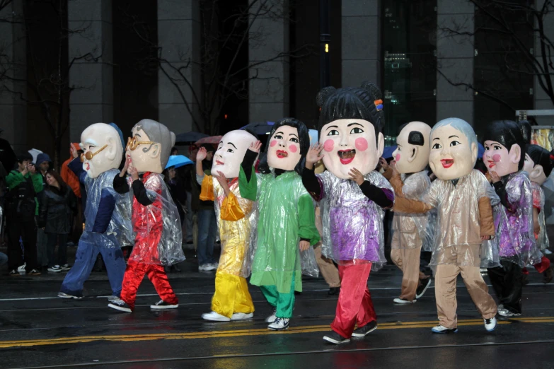 a group of people standing in the street next to each other holding different kind of puppets