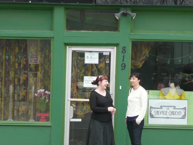 two women outside a small store talking to each other