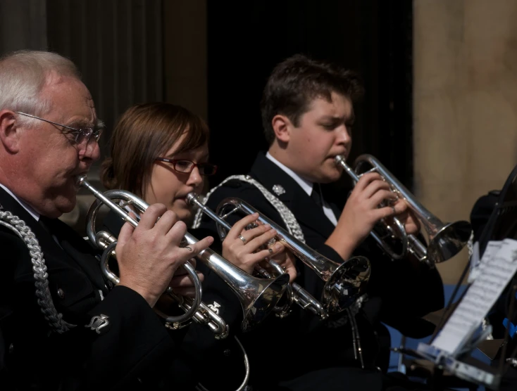 four people are playing the trombone together