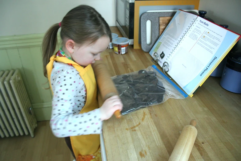 a little girl who is holding soing over a table