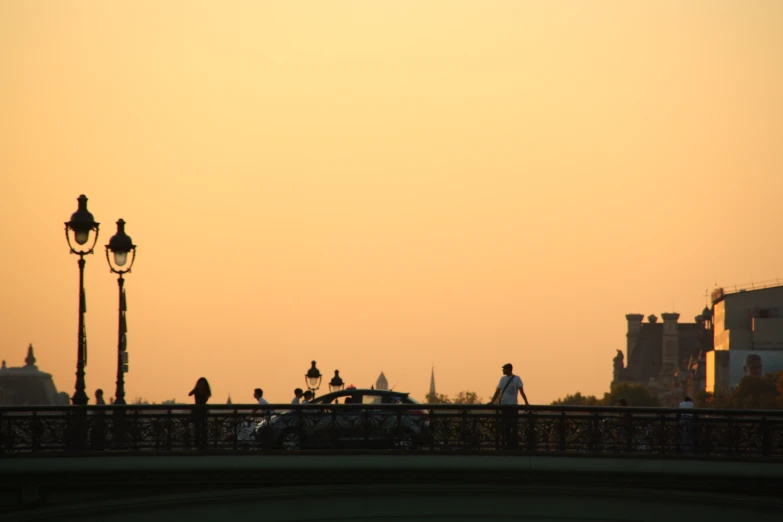 people are walking on a bridge over the river