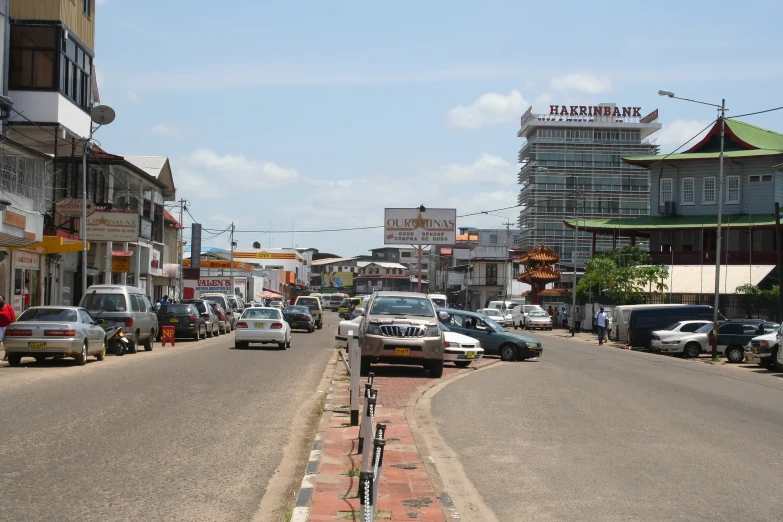 a city street with several parked cars and some signs