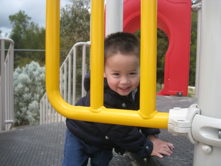 a child climbing the bars of a play ground