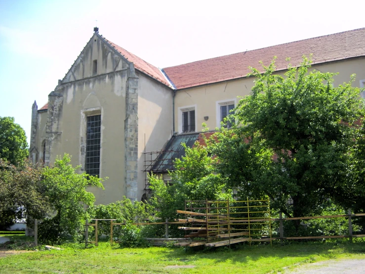 an old building with stairs and plants in front