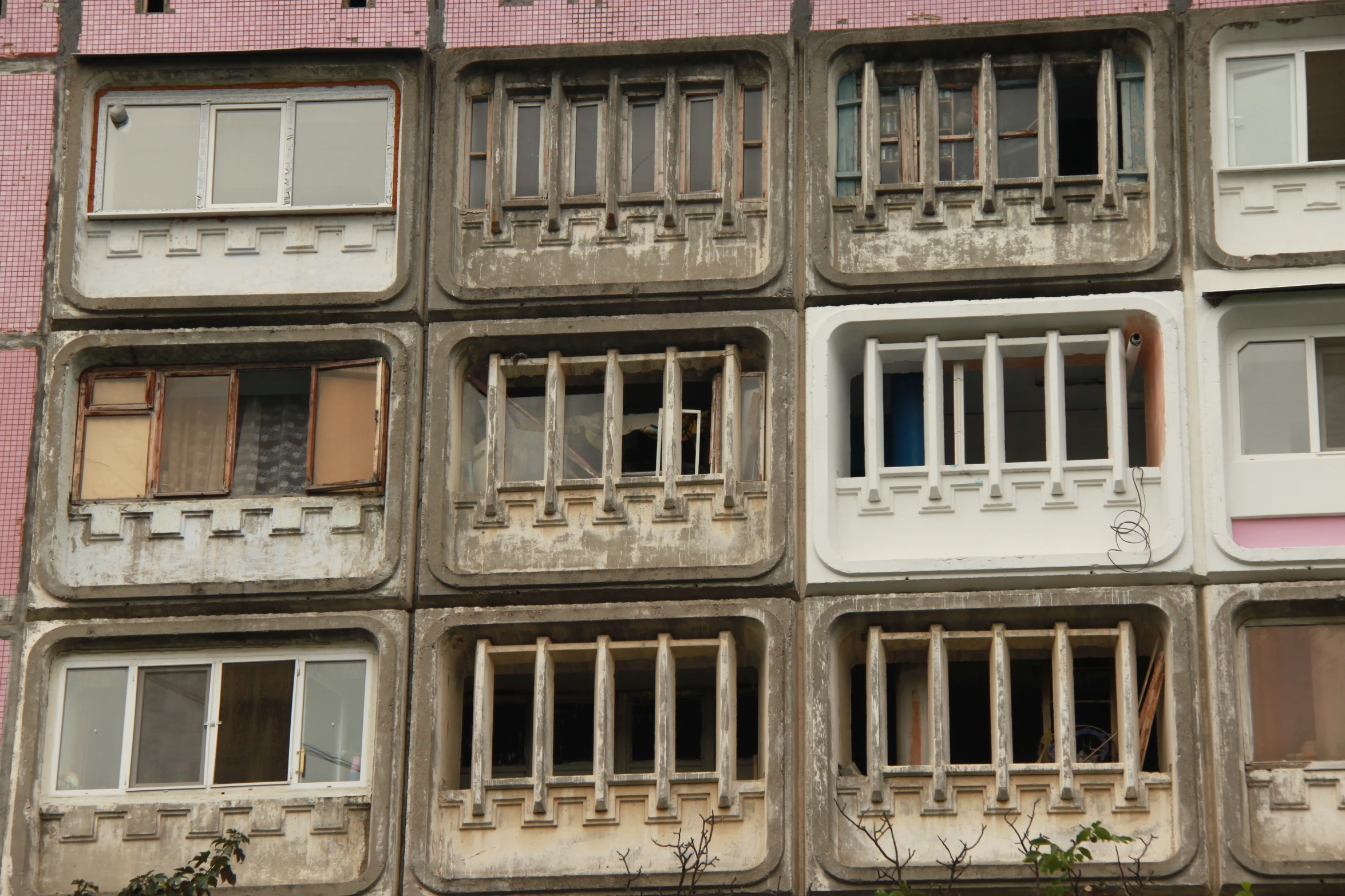 several balconies with white windows and curtains in an old building