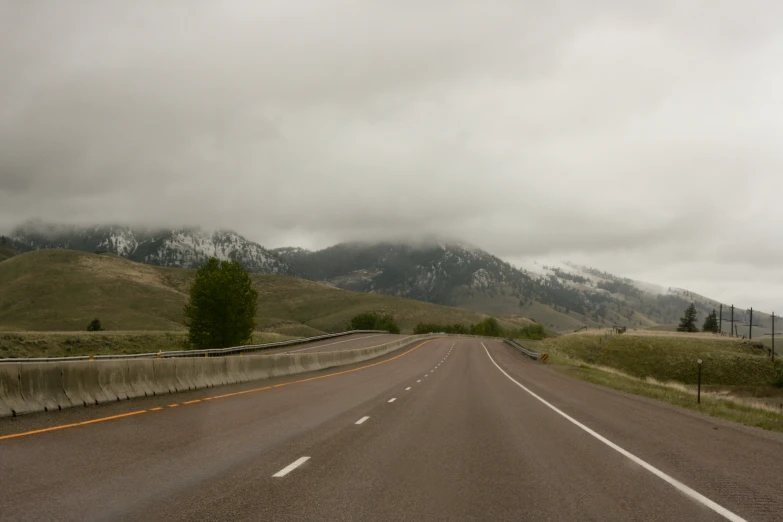 a road leading to a small mountain is empty