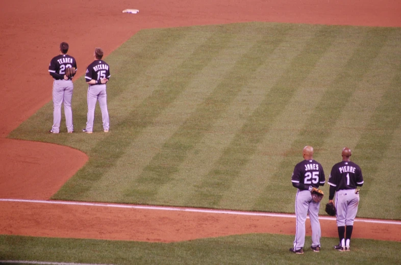 four baseball players and an umpire standing at the base