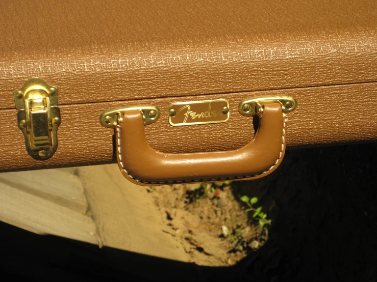 a suitcase is showing off its golden metal handle