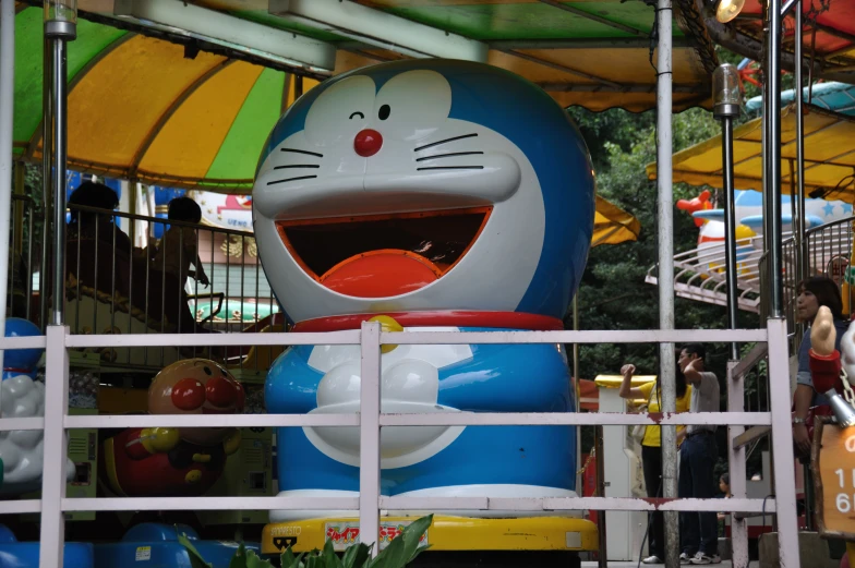 an amut park ride with a large smiling cartoon character