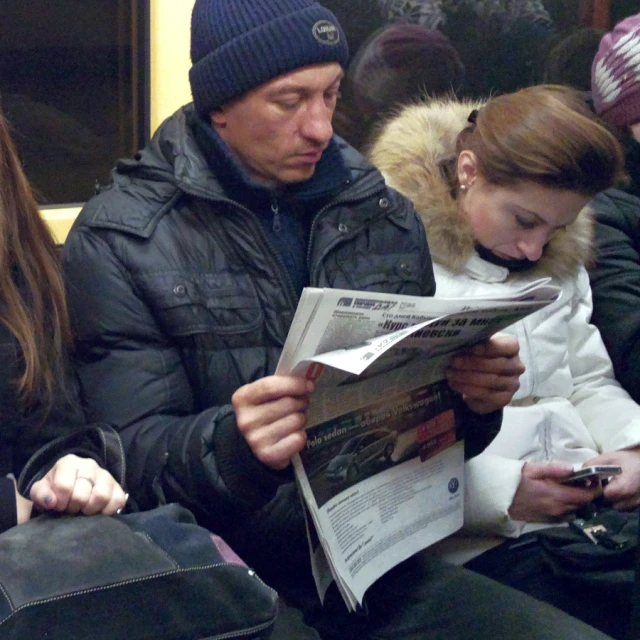 an image of man looking at paper with a girl reading