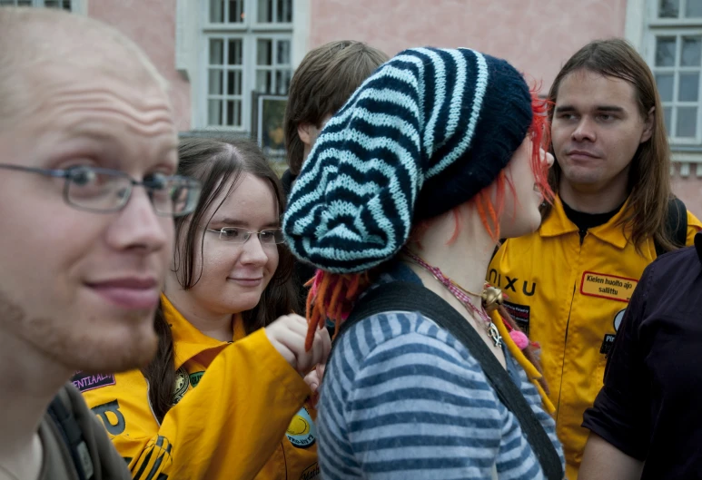 a group of people wearing a multi colored striped hat