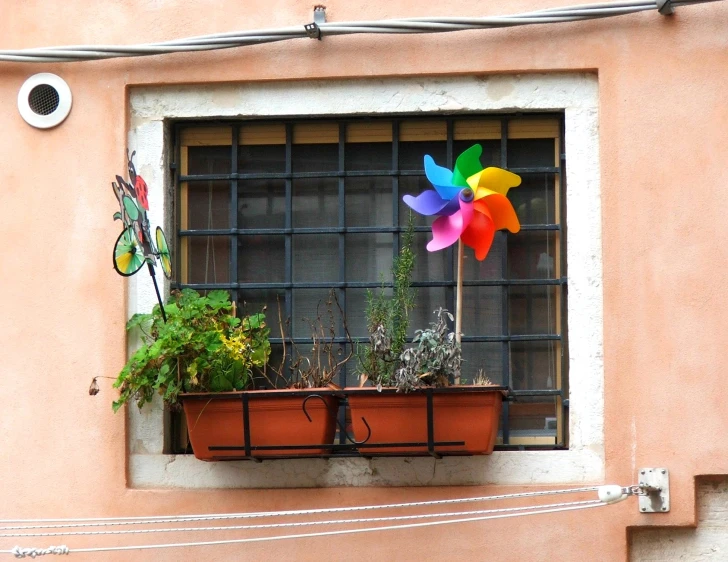 a window sill with some planters and a windmill on it