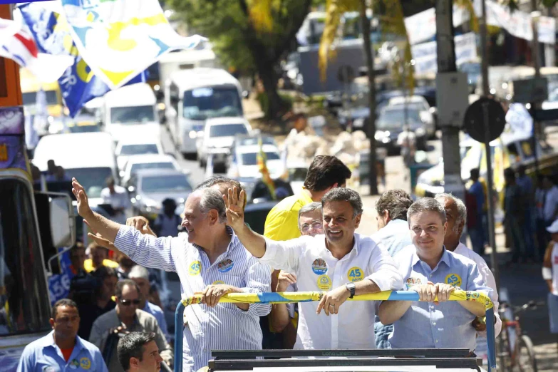 some people and two men holding soing on a vehicle