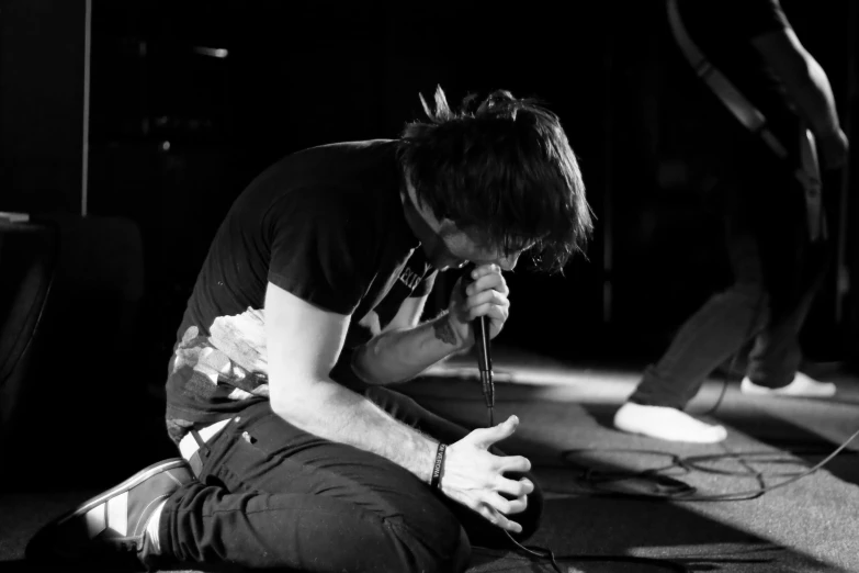 a man that is kneeling down with some kind of microphone