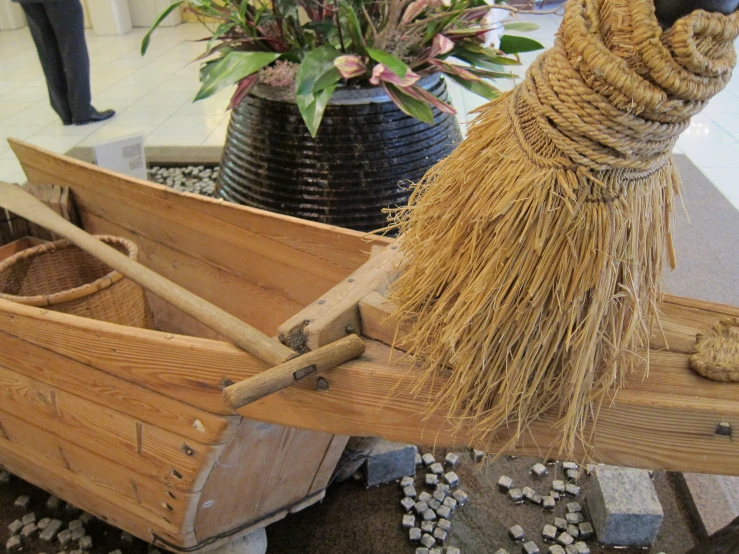 a broom being used in a small wooden boat