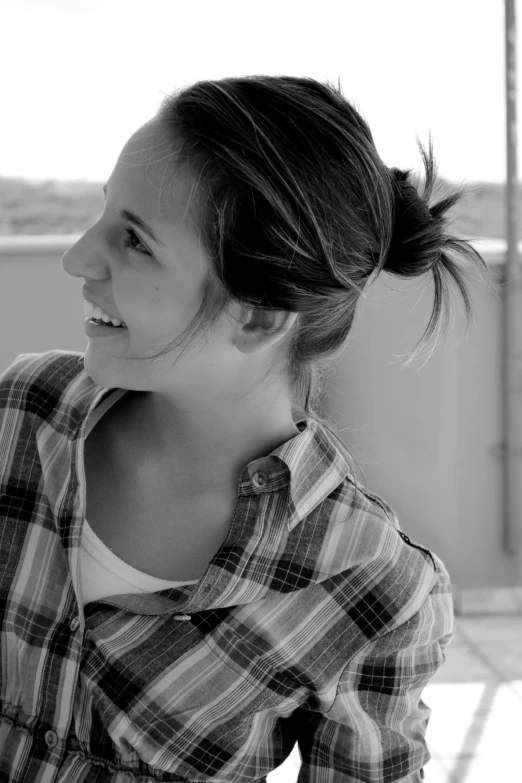 a woman wearing a checkered shirt smiling