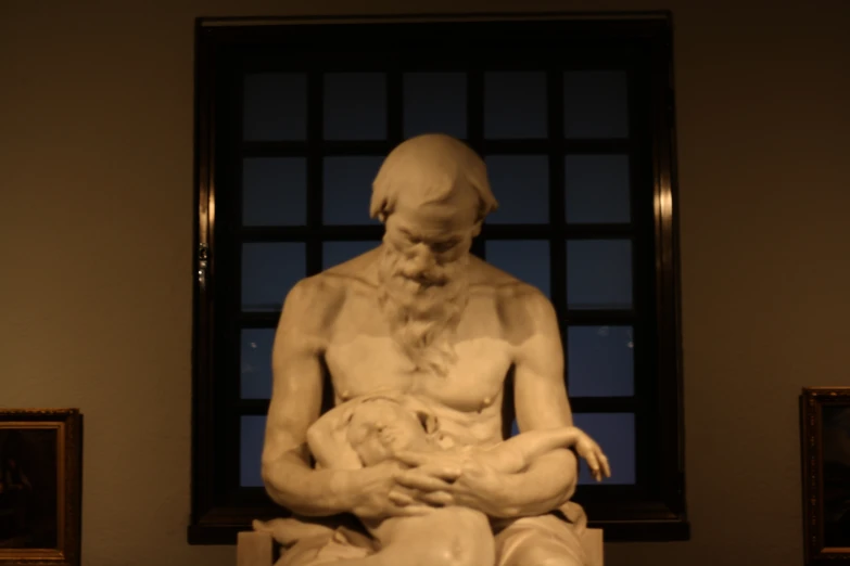 a statue sitting on a marble surface near a window