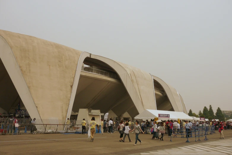 a group of people walk into an area where the top of a building looks like an arch