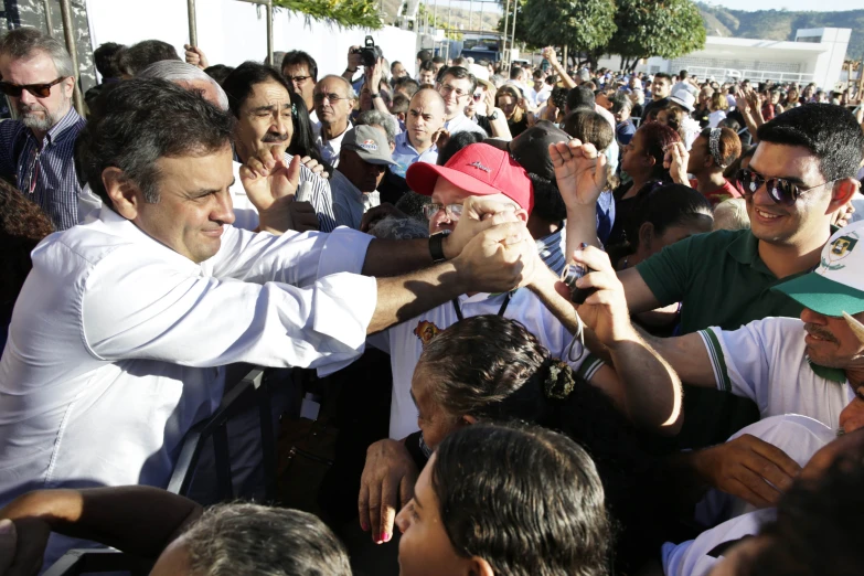 a man is greeting people who are all around him