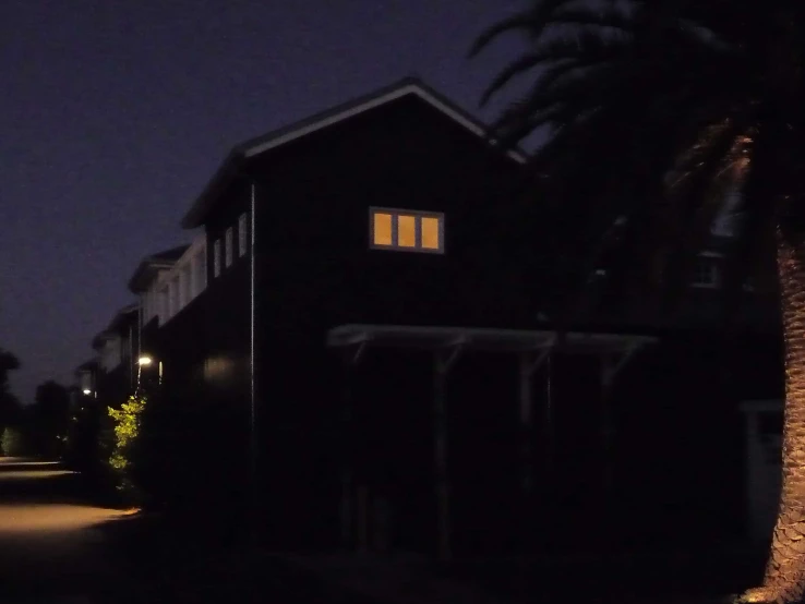 a house that has lights on at the front and side windows