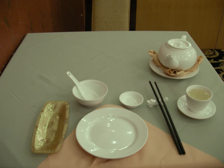 a table with a plate and tea set on it