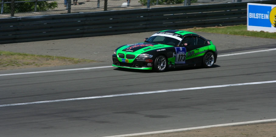 a racing car with green paint driving down the track