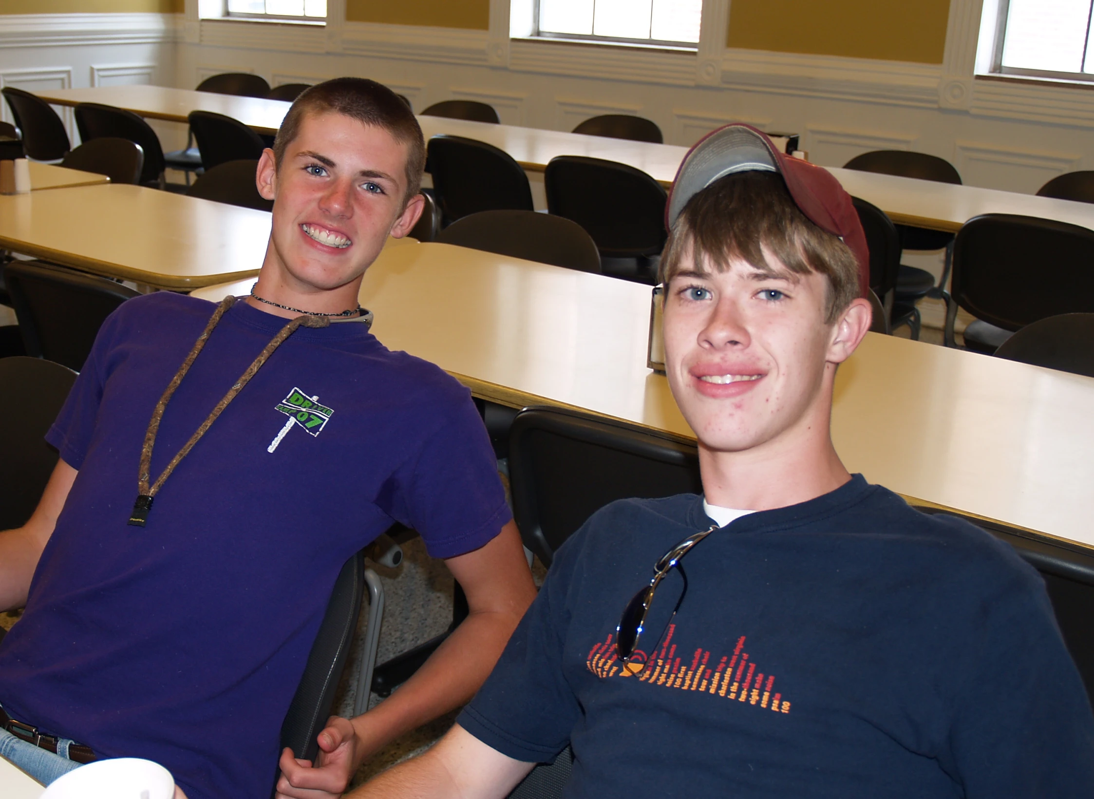 two men sitting in chairs and smiling at the camera