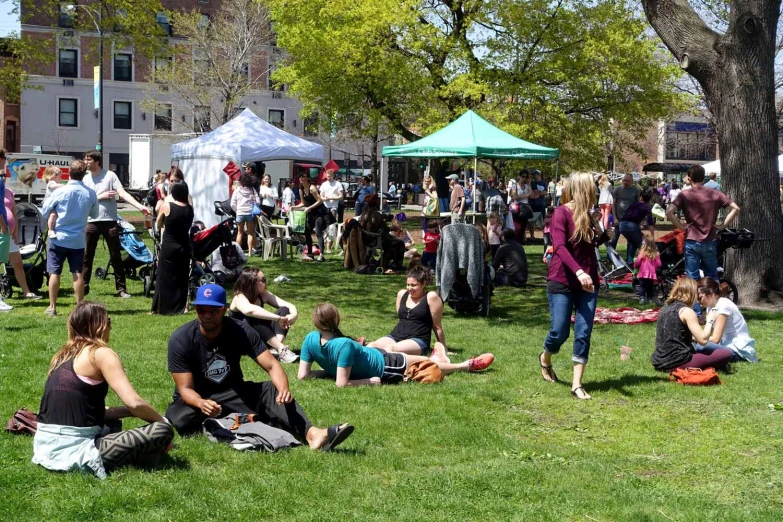 a group of people gathered on the grass in front of a building