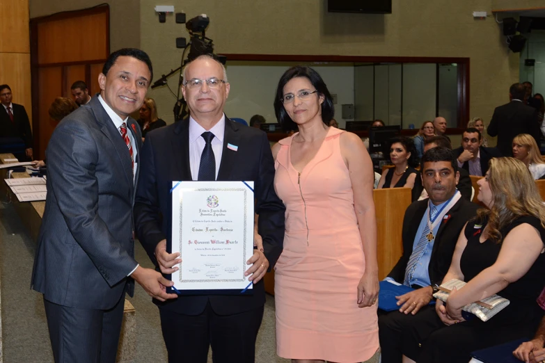 some people standing around a meeting room holding an award