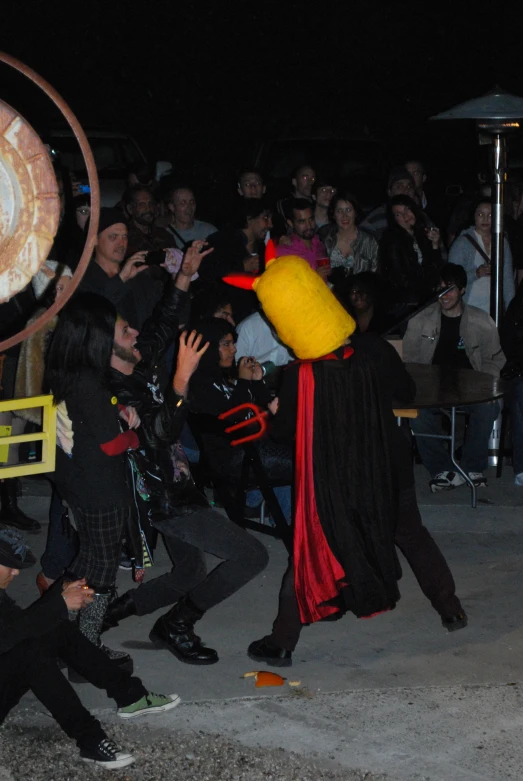 a crowd of people sitting in the middle of an outdoor dance performance