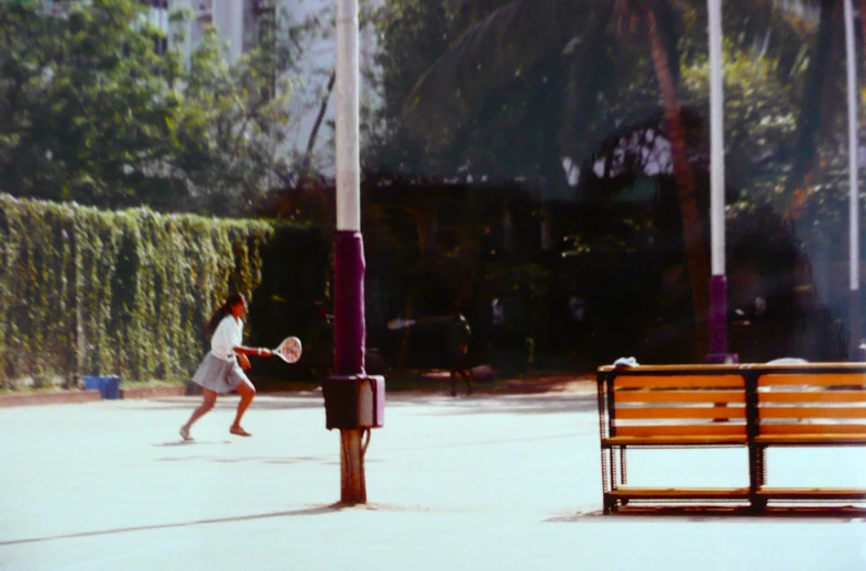 a tennis player is swinging his racket near a bench