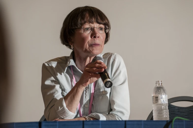 an old woman with glasses and a microphone