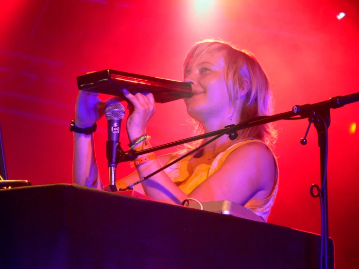 a woman in a white dress singing into a microphone