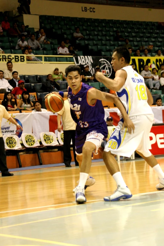 several people playing a basketball game with a crowd watching