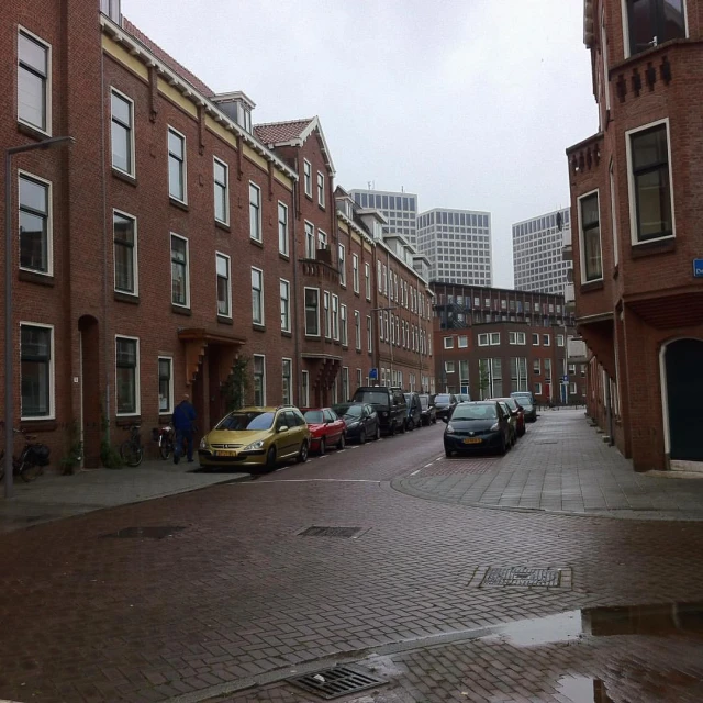 cars are parked along the street beside buildings