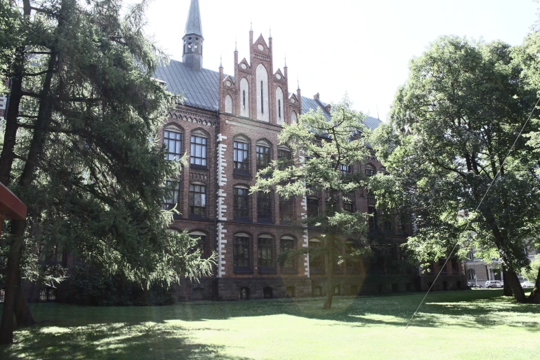 an ornate building sits behind a group of trees