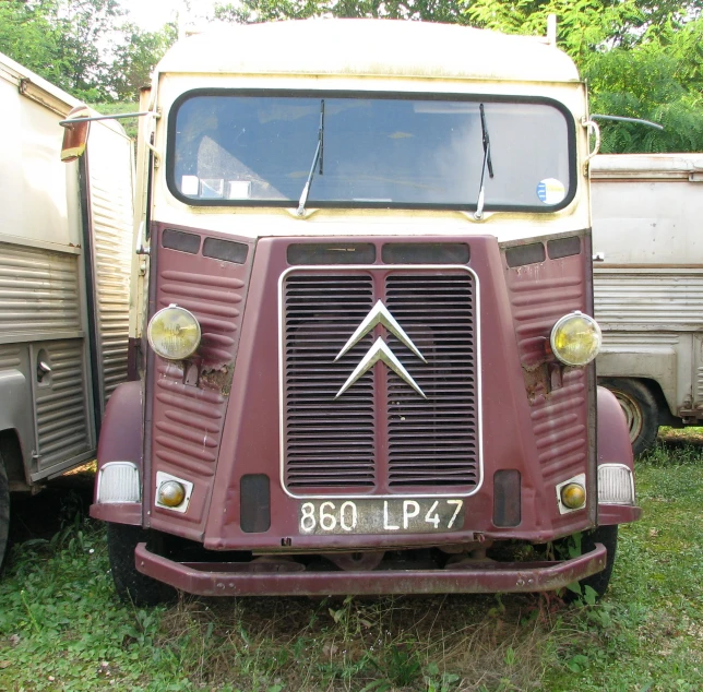 two old rusty trucks that are parked in a field