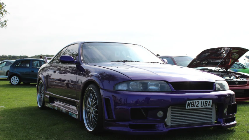 a purple car sits in front of some other cars