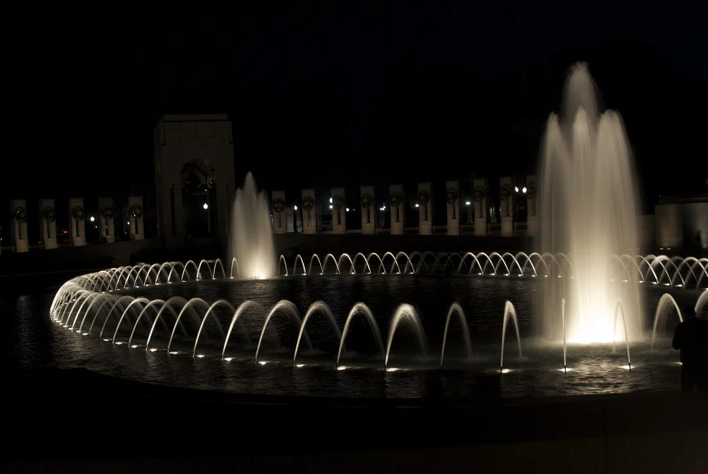 a fountain with lights and water in the dark