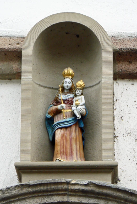 a statue of a woman holding a child on the front of a building