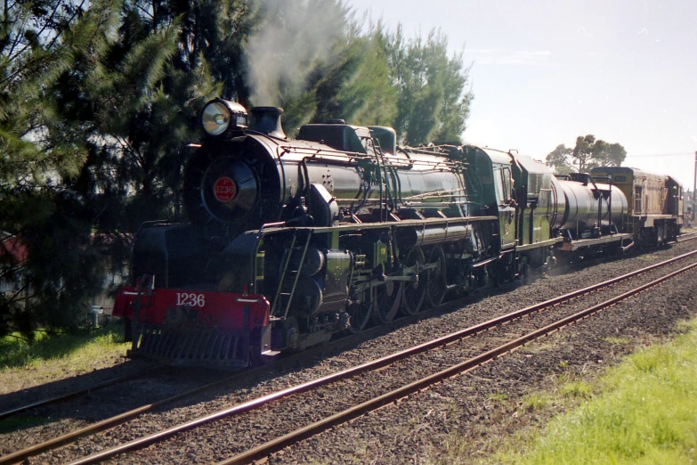 a steam engine with carts is on the tracks