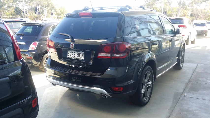 black suv parked in driveway near cars with other vehicles