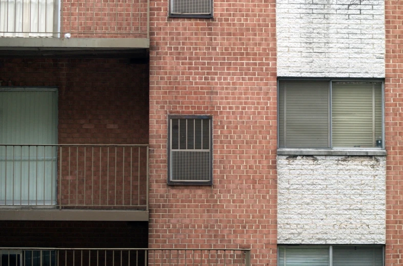a brick apartment building with windows and railing