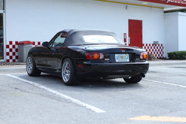 black convertible sports car parked in front of a store